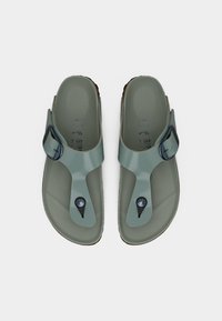 Ζευγάρι γκρι-πράσινα σανδάλια με λουράκια με ρυθμιζόμενη αγκράφα και σμιλευμένες σόλες, εμφανιζόμενα από πάνω σε λευκό φόντο.