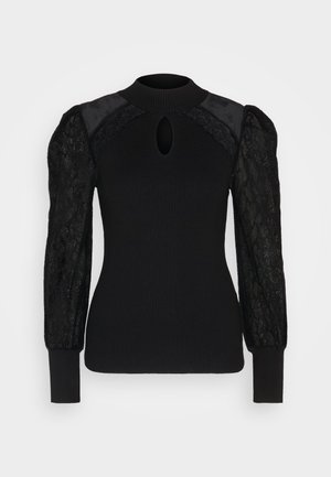 Schwarzer gerippter Pullover mit hohem Kragen, durchsichtigen Spitzen-Puffärmeln und einem Schlitzdetail auf der Vorderseite. Akzentuiert mit glatten Stoffpaneelen.