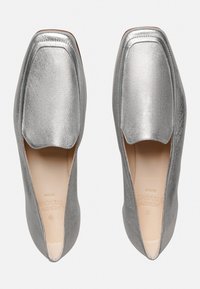 Silberne, metallische flache Schuhe mit einer quadratischen Zehenpartie und offenen Seiten. Glatte Ledertextur und beigen Einlegesohlen mit geprägt Branding.