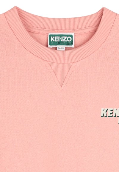 Sweatshirt rose clair avec un col côtelé et des accents sur les épaules. Présente le logo "KENZO" en vert contrastant sur le devant. Texture douce.