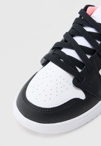 Ασπρόμαυρο αθλητικό παπούτσι με δερμάτινο επάνω μέρος με υφή, διάτρητο μπροστινό μέρος και μαύρα κορδόνια. Διαθέτει επενδεδυμένο γιακά και λευκή εξωτερική σόλα.