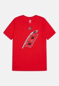 Camiseta de algodón roja con un logo de palo de hockey en blanco y negro con banderas rojas. Cuello redondo, mangas cortas, textura suave.