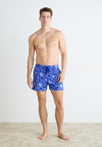 Șorturi de înot albastre cu un model floral, având un talie cu șnur, fabricate dintr-un material ușor. Textură netedă și design peste genunchi.