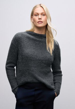 Grijs, gestructureerd sweater met een hoge kraag en lange mouwen, gecombineerd met donkere broek. Zacht, gebreid materiaal met een relaxte pasvorm.