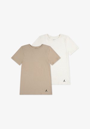 To kortermede t-skjorter: en beige og en off-white, begge laget av mykt stoff, med en svart Jumpman-logo nederst til venstre.