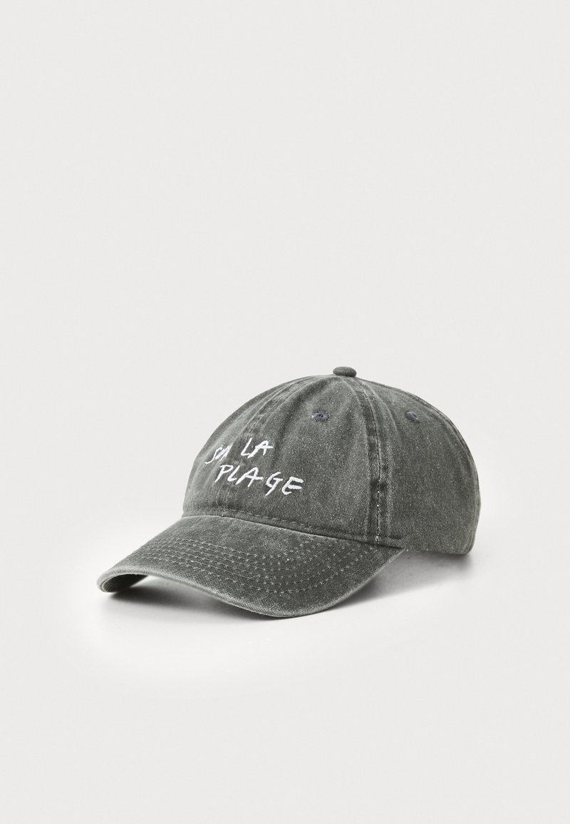 Cappellino da baseball in cotone grigio con visiera curva. Presenta la scritta bianca ricamata "à la plage" sul davanti. Sono visibili i fori di ventilazione cuciti.