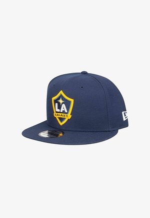 Die dunkelblaue Baseballmütze verfügt über ein gelbes und blaues LA Galaxy-Logo mit einem Wappen-Design. Sie besteht aus Stoff, hat einen flachen Schirm und eine verstellbare Passform.