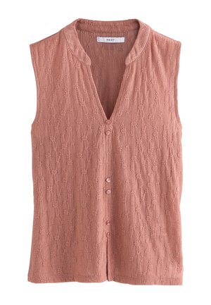 Blouse sans manches rose poudré avec motif floral texturé, petits boutons sur le devant et encolure ronde avec un petit col droit.