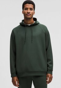 Tumma vihreä huppari, joka on valmistettu pehmeästä kankaasta. Siinä on etupuolella kengurutasku, säädettävä nyöri huppu sekä ribbikangasta hihansuissa ja helmassa.