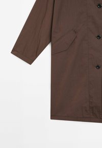 Brun, lätt jacka med en slät textur, med knappstängning, sidoficka och långa ärmar. Enkel, minimalistisk design.