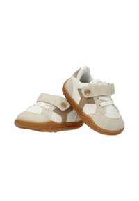 Zapatillas beige y blancas para niños pequeños con detalles en marrón, cierres de velcro y suelas de goma, colocadas sobre un fondo blanco.