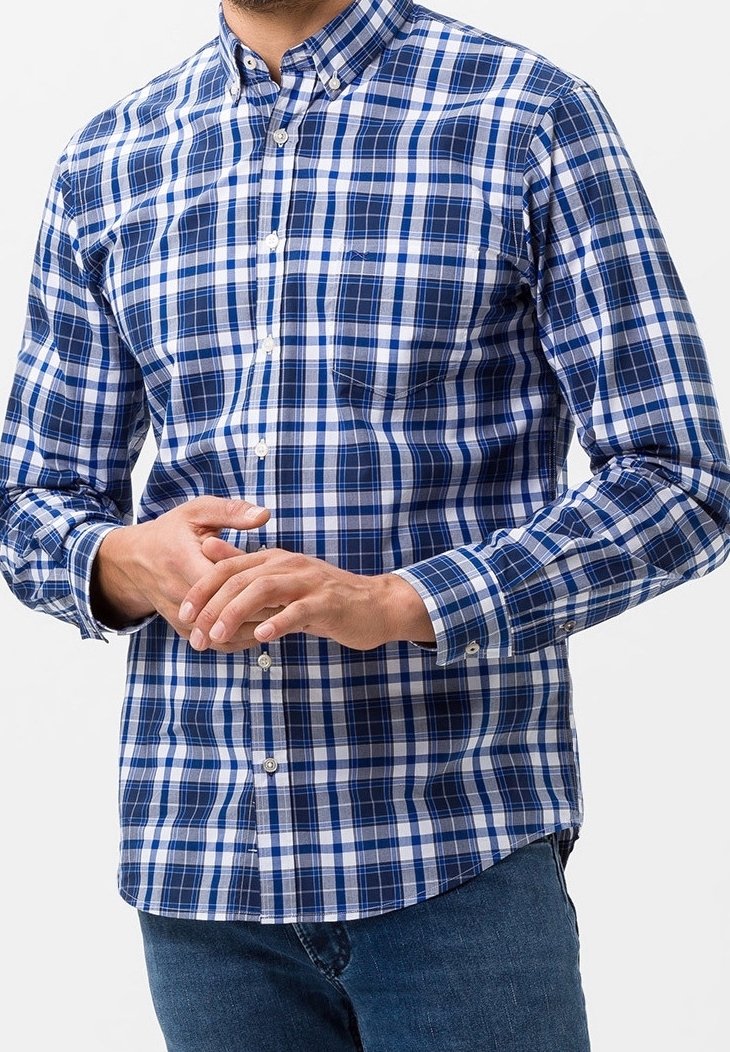 Modrá a bílá kostkovaná košile s límečkem na knoflíky, dlouhými rukávy a detailem kapsy. Bavlněná tkanina s hladkým povrchem a rovnoměrným vzorem.
