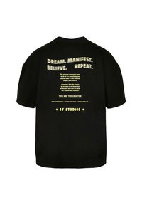 Black cotton t-shirt with short sleeves. Text in yellow on the back includes motivational phrases and branding for "2Y STUDIOS."