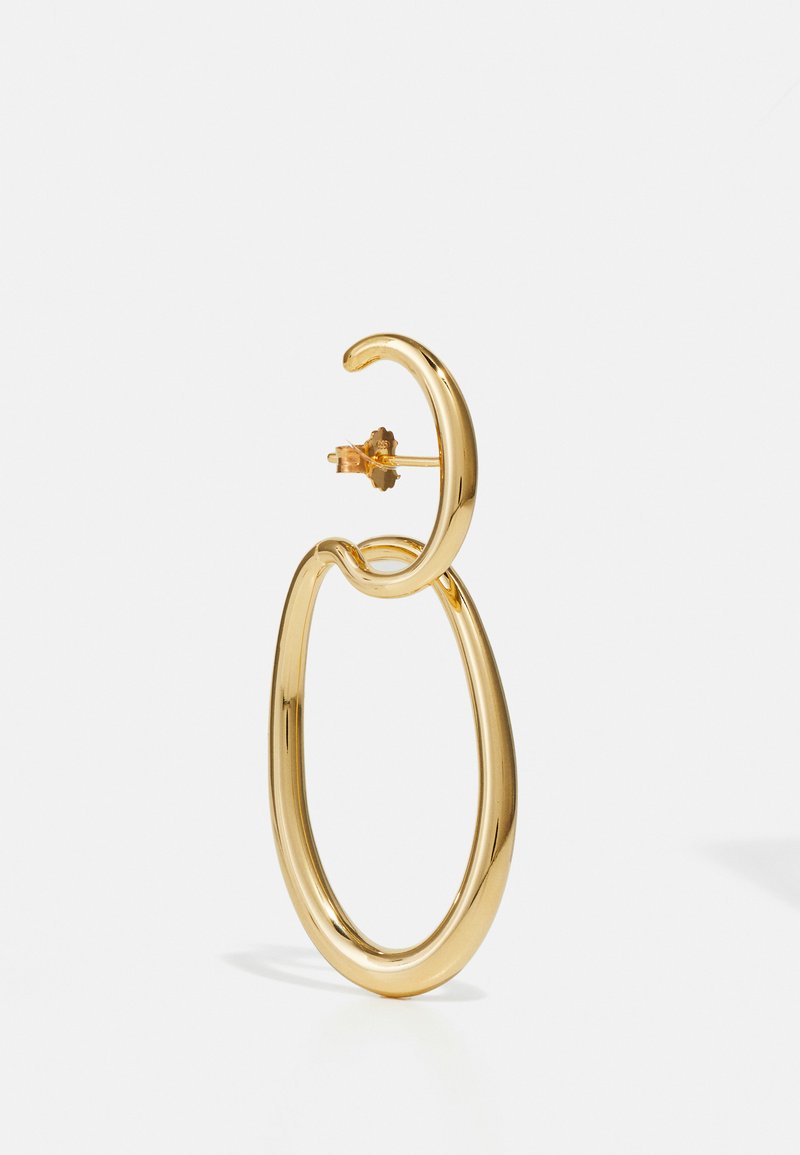 Auksinės spalvos metalinės auskarai su lankia forma ir apvaliu akcentu viršuje. Lygus paviršius ir blizgus apdaila.