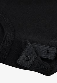 Mustast puuvillasest kangast rõivas, millel on soonikuga kaelus ja hemmi all pressnööbid, pakkudes istuvat stiili ja sujuvat tekstuuri.