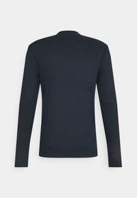 Camicia a maniche lunghe di colore blu navy realizzata in un tessuto morbido e testurizzato, con colletto rotondo e design minimalista privo di qualsiasi marchio visibile.