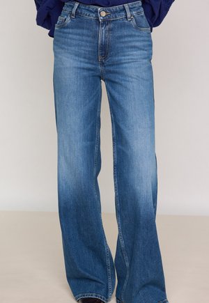 Jeans in denim con un lavaggio azzurro chiaro, design a gamba larga, classico stile a cinque tasche e chiusura frontale con bottoni e zip.