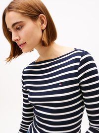 Marineblauw en witte gestreepte lange mouw top met een bootnek en een klein logo detail op de borst, gemaakt van zachte katoenen stof.