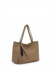 Hellbraune Leder-Umhängetasche mit zwei Schulterriemen, feiner perforierter Struktur und einem dekorativen schwarzen Anhänger mit der Aufschrift "SURI FREY".