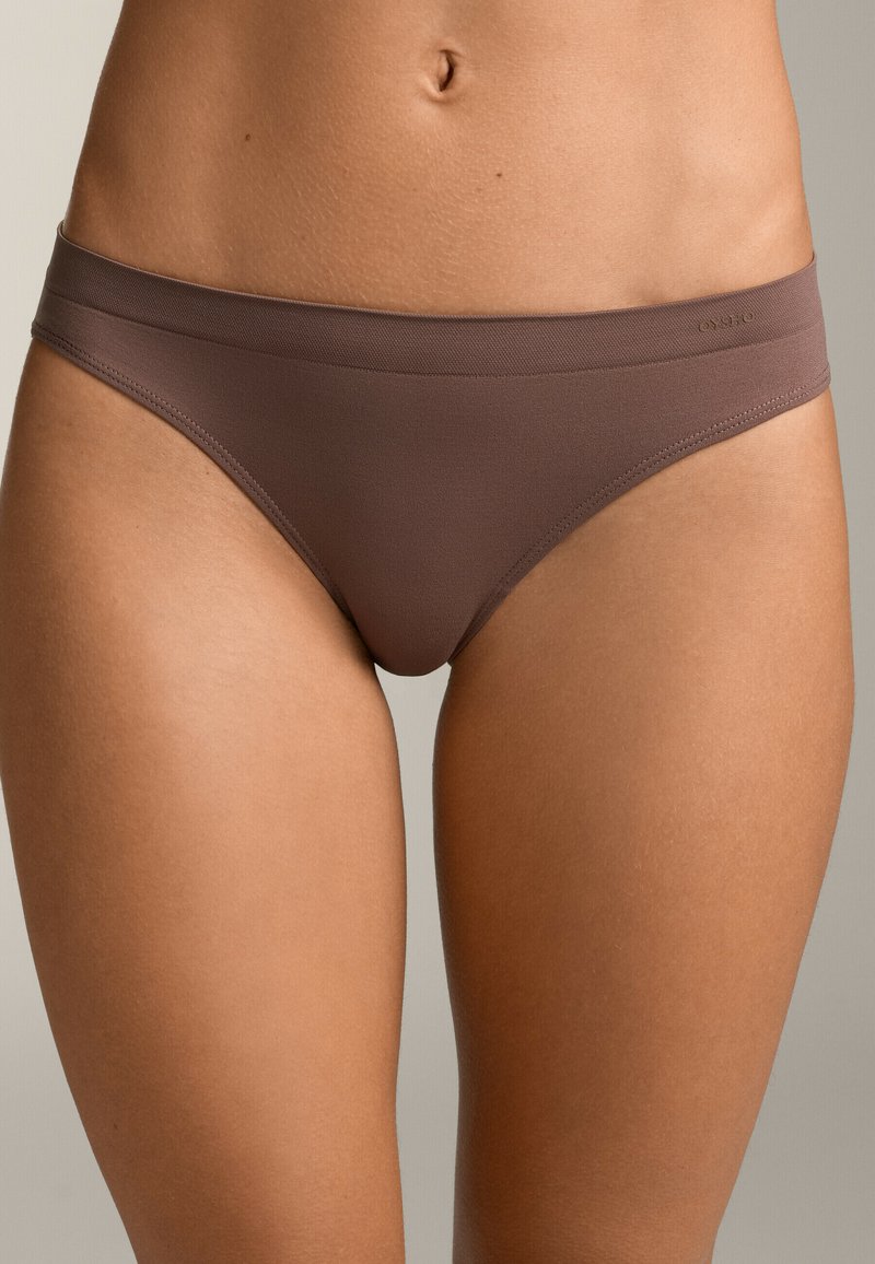 Rjav bikini spodnjice z gladko teksturo, nizkim rezom in širokim elastičnim pasom. Ponaša se s minimalnim logotipom vtisnjenim na strani.