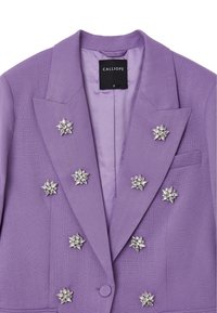 Blazer lilla con una finitura texturizzata, adornato con spilli d'argento con motivi floreali. Interno foderato e chiusura a un bottone.
