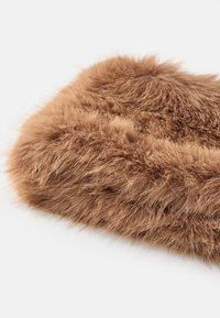 Coussin en fausse fourrure brune avec des fibres longues et douces ; les bords arrondis accentuent sa texture moelleuse et sa couleur chaude. Convient à un usage décoratif.