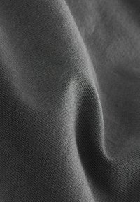 Sötétszürke szövet, amely puha textúrájú és enyhe fényű, sima, szőtt mintázattal és finom mélységi valamint fényvariációkkal.