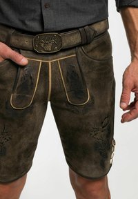 Bruine leren shorts met gedetailleerde zwarte borduursels en lichtbruin stikwerk. Voorzien van een riem met een decoratieve metalen gesp en knoopaccenten.