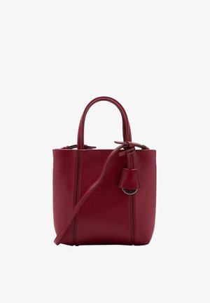 Sac fourre-tout en cuir rouge avec une finition texturée, deux poignées supérieures, une bandoulière ajustable et une petite étiquette attachée.