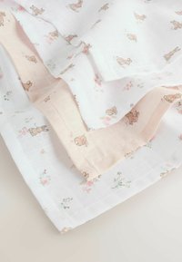 Cotton baby blanket featuring a white base with floral patterns and small rabbits, trimmed with a soft pink edge.
