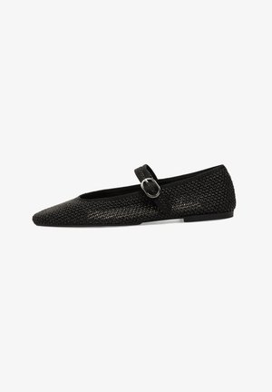 Bailarina negra tejido con punta afilada, con una correa con hebilla en el empeine. Suela plana, superficie texturizada y diseño minimalista.