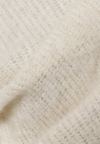 Hvit, myk stoff med en teksturert, åpen vevemønster. Materialet ser ut til å være lodden og lett, med fine fibre synlige gjennom hele.