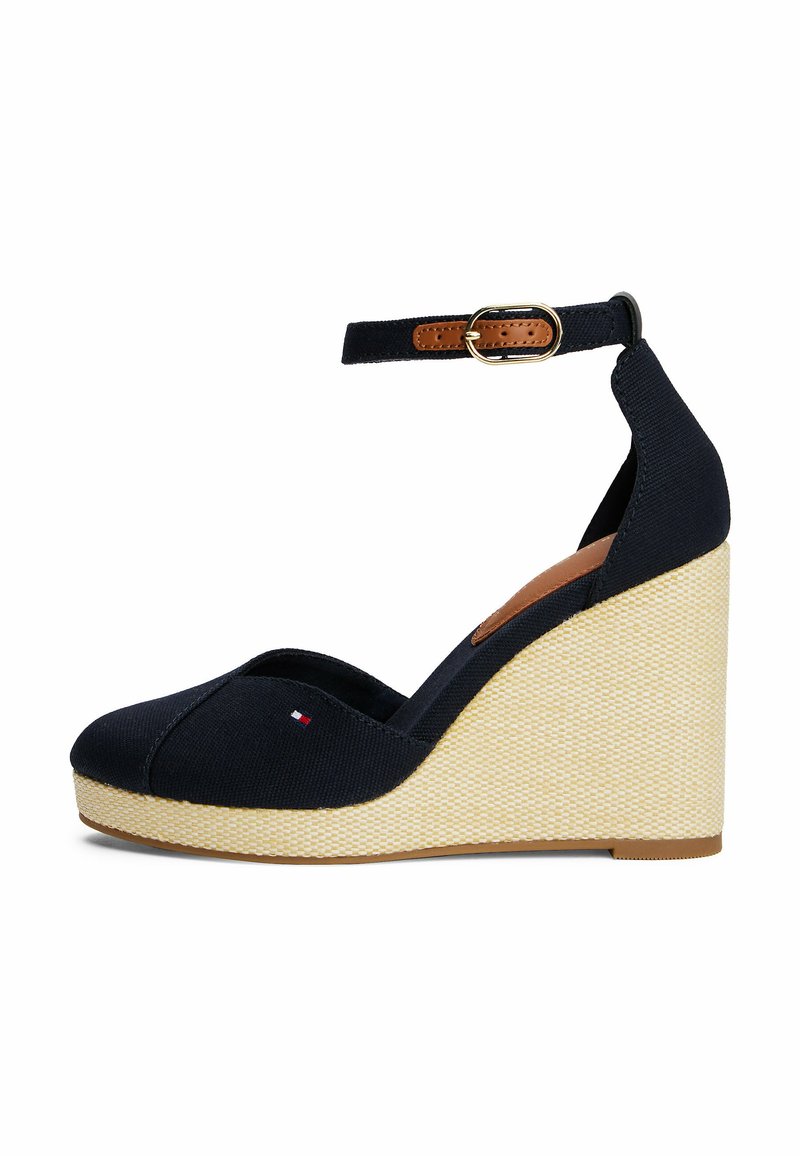 Navy canvas wedge shoes with an open toe, ankle strap, and a beige woven platform. Features a small logo accent on the front.
