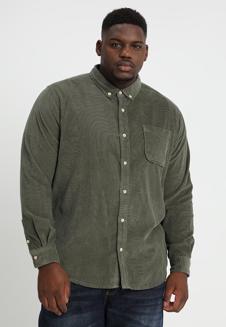 Camicia in corduroy verde scuro con colletto button-down, maniche lunghe, taschino sul petto e bottoni beige, caratterizzata da un tessuto testurizzato.