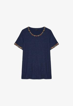 Granatowy top z krótkim rękawem, okrągłym dekoltem i wielokolorową ozdobą z koralików na kołnierzu i mankietach.