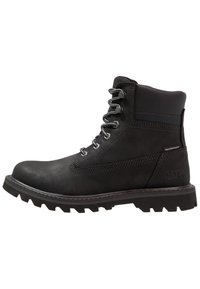Las botas impermeables negras cuentan con un diseño robusto, material de cuero, acentos de costura y una suela de goma resistente con dibujos profundos para tracción.