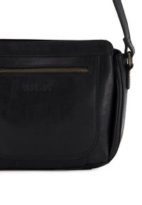 Black leather shoulder bag with a front zippered pocket, visible stitching, and an adjustable strap. Brand logo embossed on the front.
