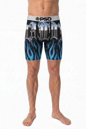 Mann trägt schwarze Boxer-Shorts mit blauen Flammen und silbernem gotischem Text, steht barfuß vor weißem Hintergrund.