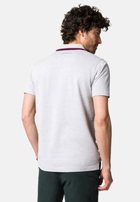 Jasnoszara koszulka polo wykonana z miękkiego materiału, z kołnierzykiem w granatowe i czerwone akcenty, krótkimi rękawami oraz dyskretnym logo z tyłu.