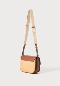 Borsa a tracolla in pelle marrone con frontale in paglia naturale testurizzata, tracolla crema regolabile e dettagli in metallo dorato. Forma rettangolare.