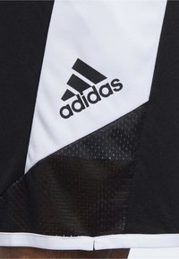 Adidas Sportshorts in einem schwarz-weißen Farbschema, mit einem atmungsaktiven Netzpaneel und dem markanten schwarzen Logo auf der linken Seite.
