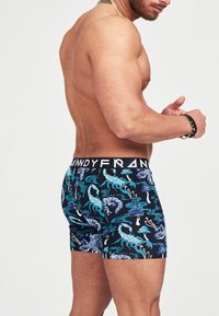Boxer da uomo con cinturino nero, caratterizzati da un motivo multicolore di scorpioni ed elementi acquatici su uno sfondo scuro.