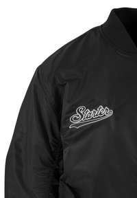 Jachetă bomber neagră din nylon neted, cu manșete și guler elastice, având logo-ul alb brodat "Starter" pe partea stângă a pieptului.