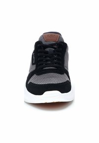 Black, gray, and white sneaker features mesh upper, suede accents, rubber sole, and flat laces. Tan logo patch on tongue adds detail.