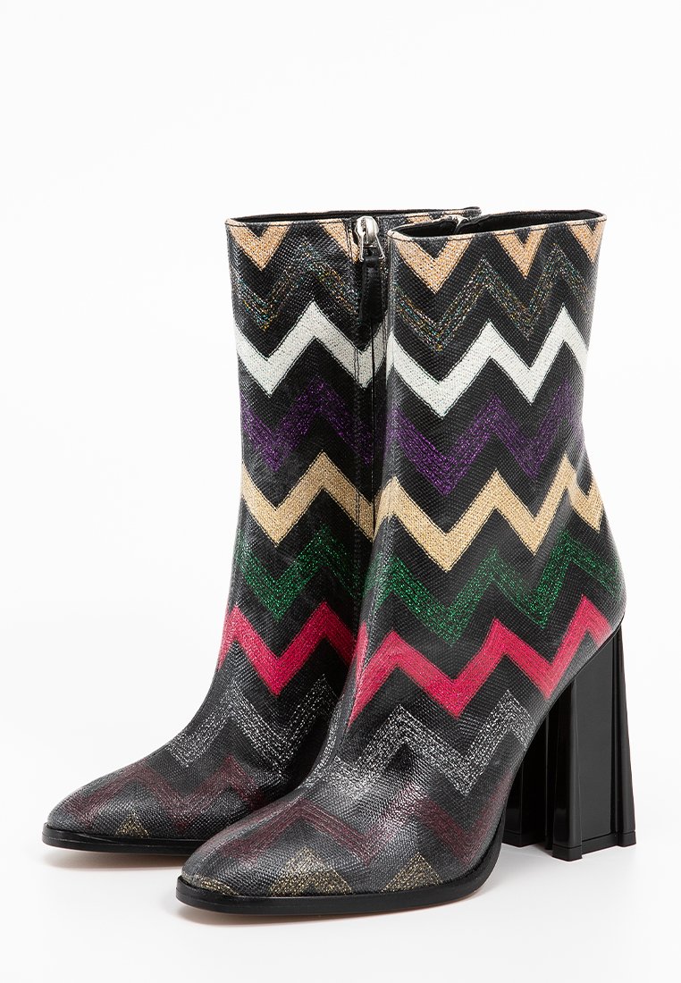 Hochhackige Knöchelstiefel mit einem Zickzackmuster in Schwarz, Gold, Weiß, Lila, Grün und Pink. Glänzende Textur mit spitz zulaufender Zehenpartie.
