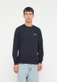 Granatowy sweatshirt z długimi rękawami, okrągłym dekoltem i małym logiem górskim. Wykonany z teksturowanej tkaniny, posiada ściągacze przy mankietach i w pasie.