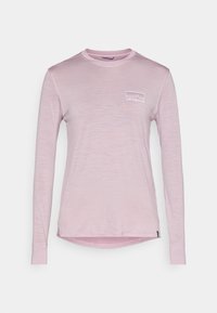 Μακρυμάνικο ροζ μπλουζάκι από απαλό ύφασμα, με μικρό λευκό λογότυπο Patagonia στο αριστερό στήθος και στρογγυλεμένη σχεδίαση στο κάτω μέρος.