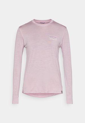 Μακρυμάνικο ροζ μπλουζάκι από απαλό ύφασμα, με μικρό λευκό λογότυπο Patagonia στο αριστερό στήθος και στρογγυλεμένη σχεδίαση στο κάτω μέρος.