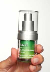 Tydlig glaspumpflaska med silverlock; ljusgrön serum inuti märkt "Murad Retinol Youth Renewal Eye Serum."