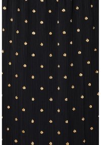 Tissu noir avec des plis verticaux ornés de petits pois métalliques dorés dispersés, de tailles et formes irrégulières.